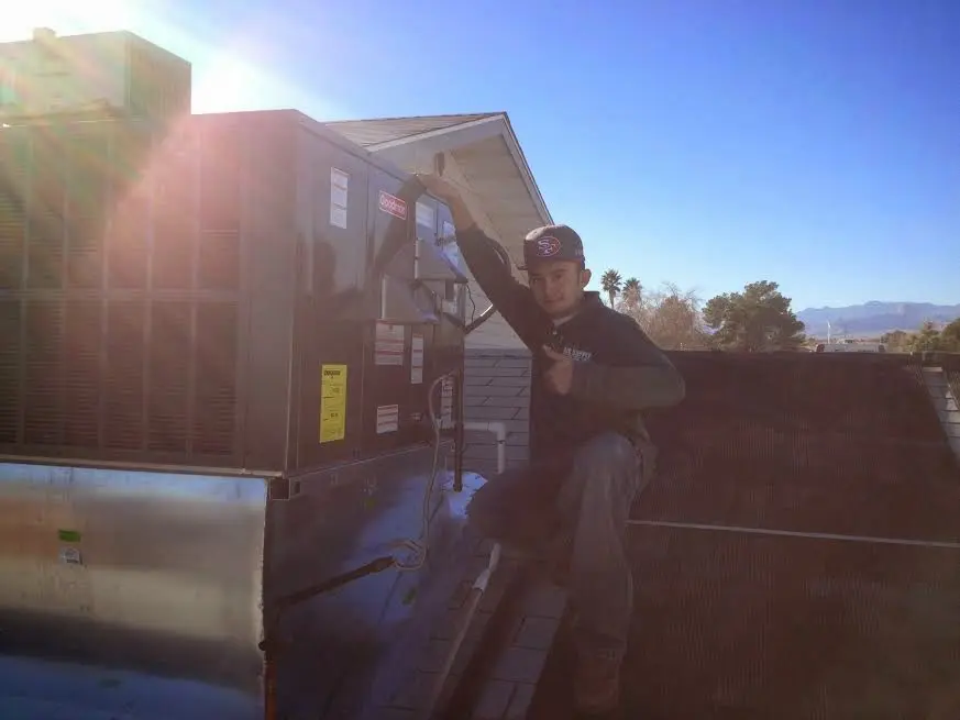 HVAC technician performing AC Tune-Up on a rooftop unit in Walnut Park